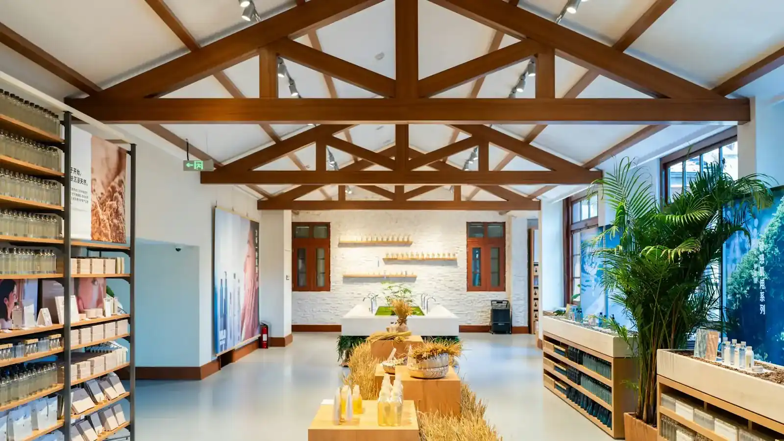Lichte winkel met houten dakspanten, schappen langs de wanden en een presentatietafel